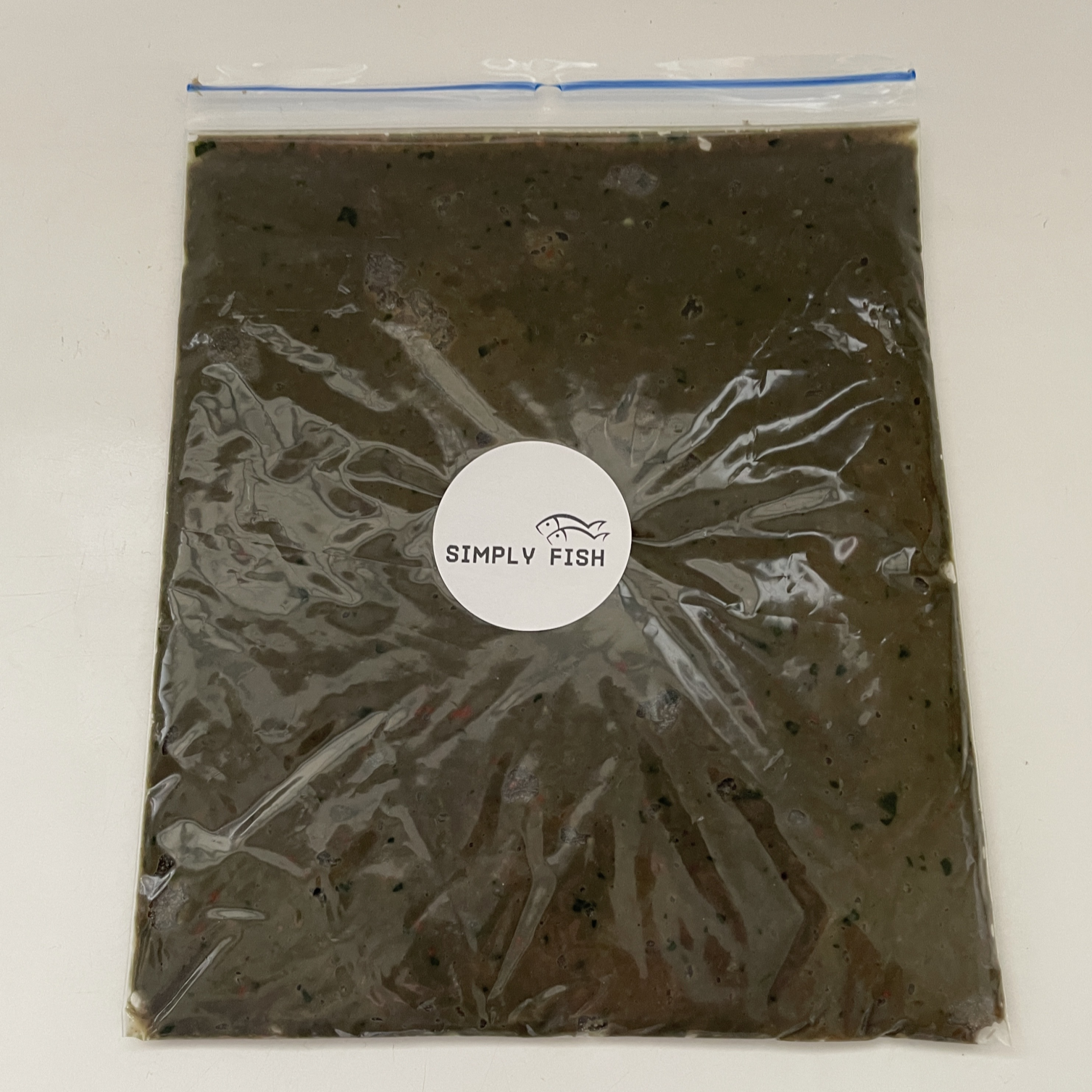 A sealed, frozen bag of frozen beefheart discus food labeled 'SIMPLY FISH'
