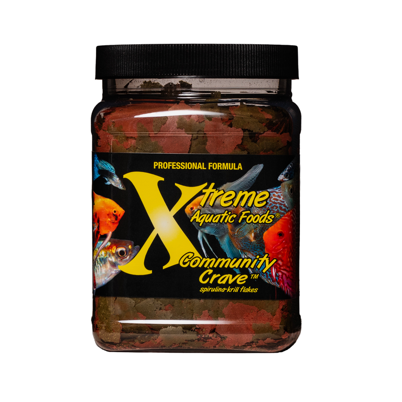 A clear container of Xtreme 454g Community Crave Flake fish food, showing the product name and description, alongside a label showing various fish.