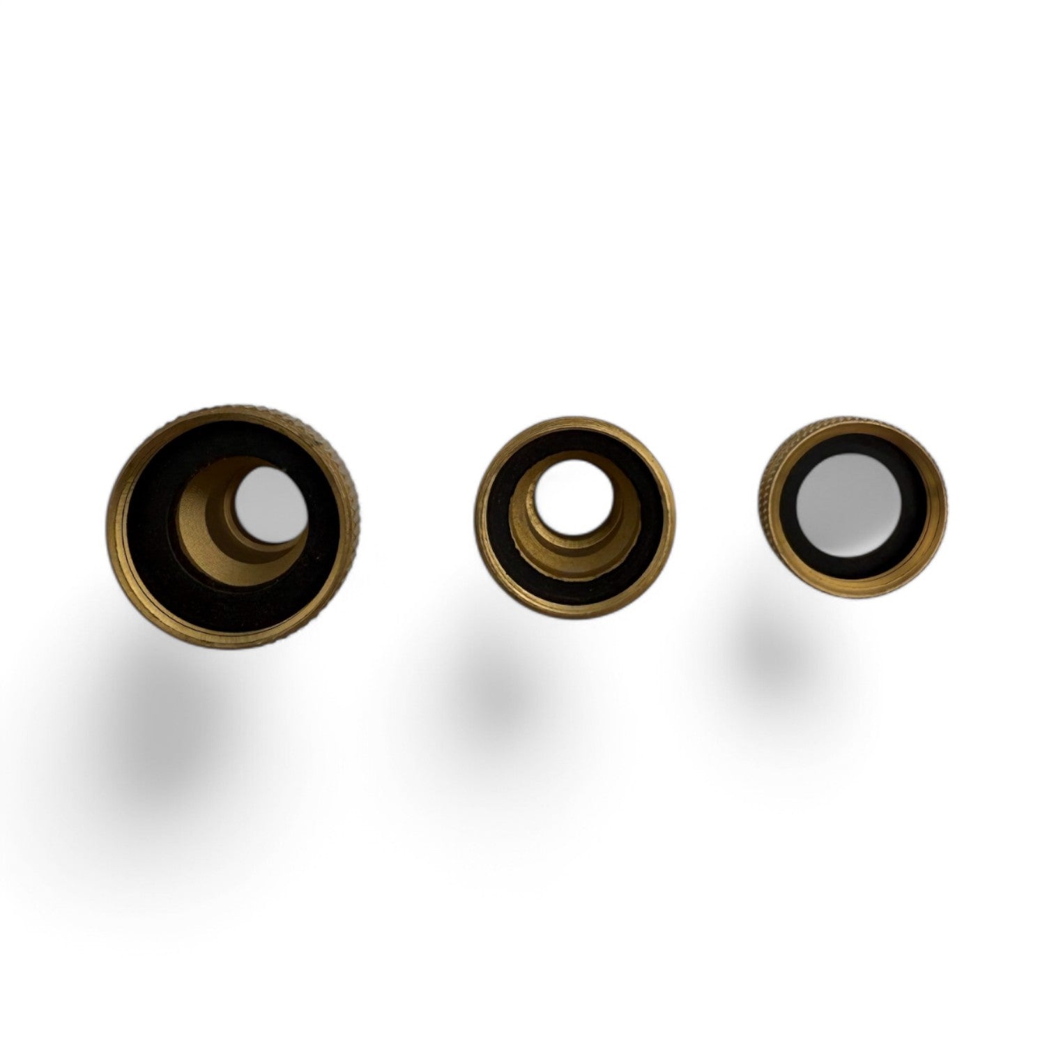 Three brass circular objects with black o-rings on a white background